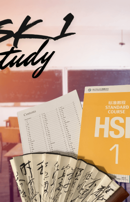 a picture of the orange and white HSK 1 study booklet in a classroom setting, accompanied by a delicate Chinese fan with beautiful calligraphy written on it.